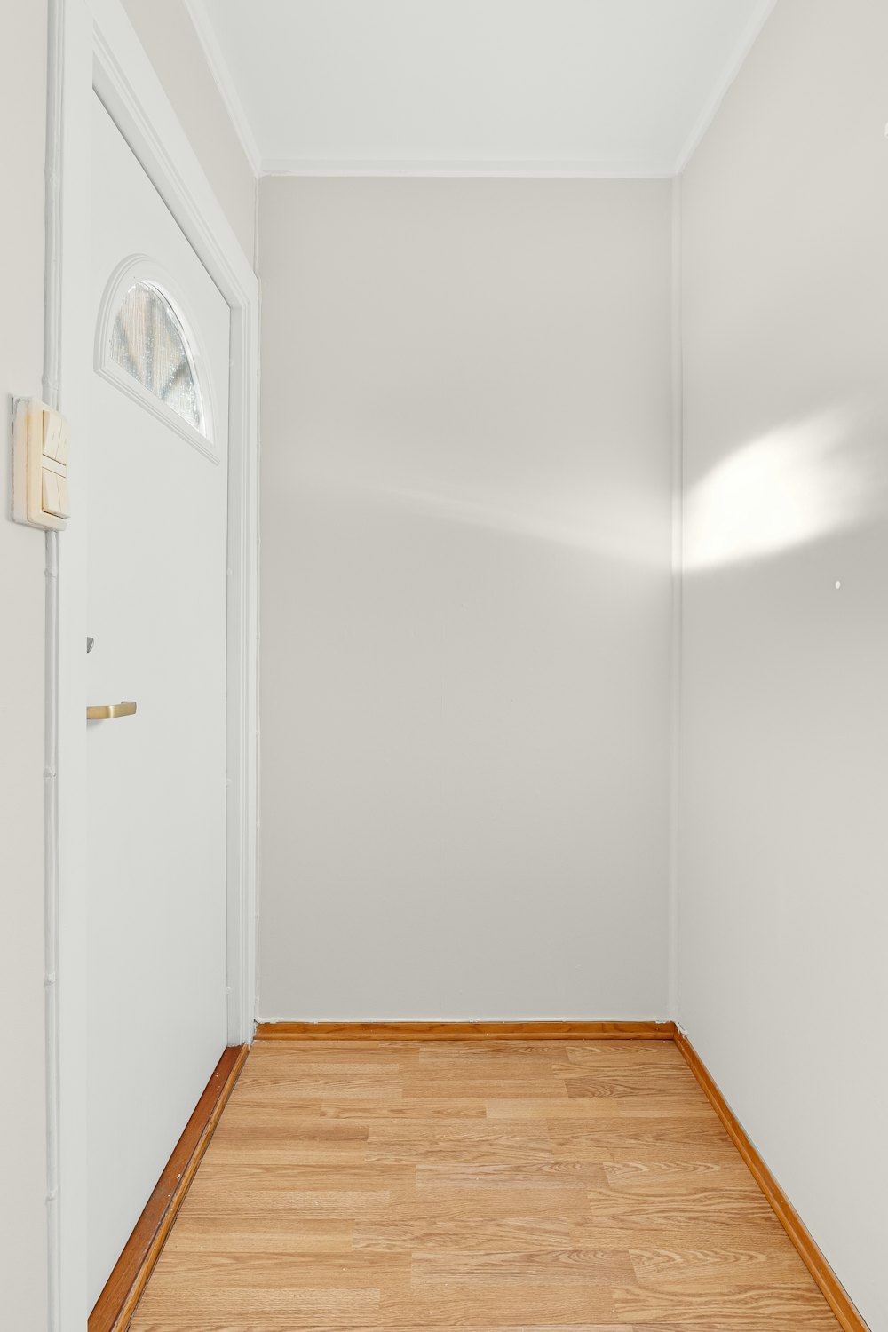 A bright, empty room with clean hardwood floors after a complete cleanout